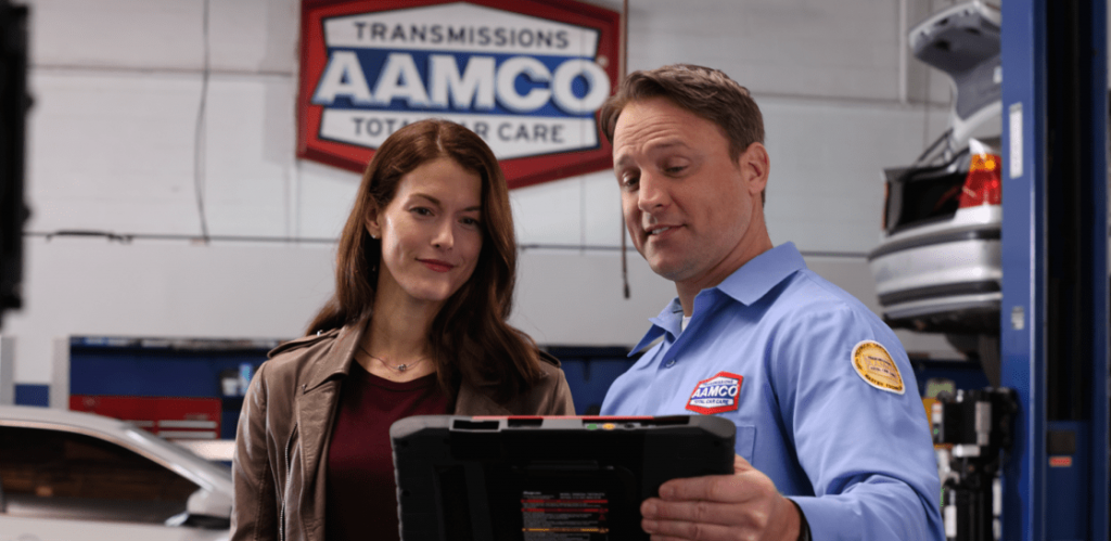 AAMCO franchise automotive technician showing customer the scanner results for auto repair work
